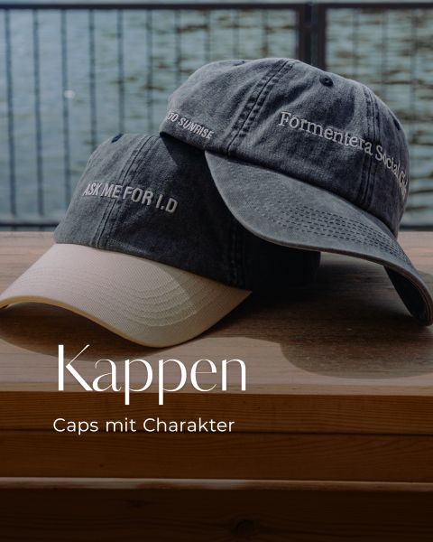 Zwei Kappen auf einer Holzbank am Wasser; auf der einen steht „ASK ME FOR I.D.“, auf der anderen „Formentera, Social Club“. Text: „Kappen – Caps mit Charakter.“.