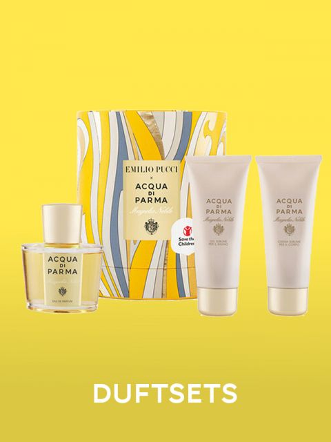 Ein Parfüm-Geschenkset mit Acqua di Parma-Artikeln, darunter eine Flasche Parfüm und zwei Tuben Lotion, präsentiert vor einem gelben Hintergrund. Die Verpackung weist ein farbenfrohes, welliges Design und den Text „EMILIO PUCCI“ auf.