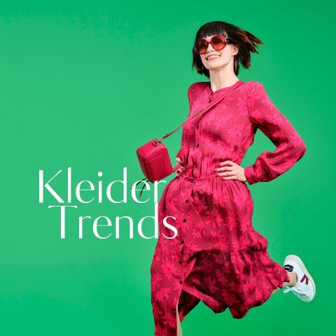 Eine Frau in einem leuchtend rosa Kleid und weißen Turnschuhen posiert fröhlich vor einem hellgrünen Hintergrund. Sie trägt eine rote Handtasche und eine Sonnenbrille. Neben ihr steht der Text „Kleider Trends“.