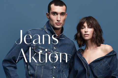 Ein Mann und eine Frau in Jeansjacken posieren vor einem blauen Hintergrund. Der Mann hat kurze Haare, die Frau schulterlanges Haar. Auf der linken Seite des Bildes steht der Text „Jeans-Aktion“.