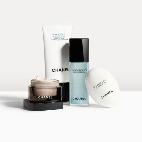 Vier Hautpflegeprodukte von Chanel sind vor einem hellen Hintergrund angeordnet: ein Reinigungsschaum, ein Mikroserum, eine Feuchtigkeitscreme und eine Handcreme, jeweils in einer individuellen Verpackung mit sichtbarem Markenlogo.