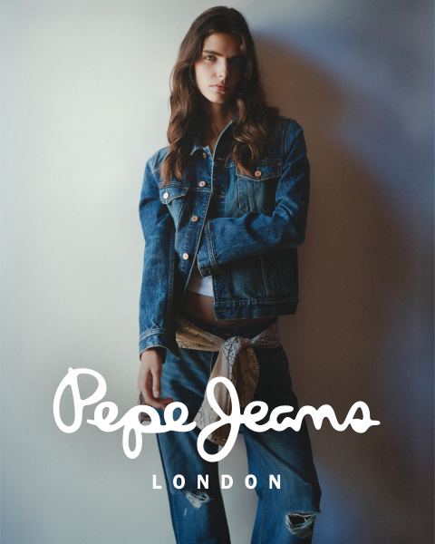 Eine Frau in Jeansjacke und Jeans posiert vor einem neutralen Hintergrund, im unteren Bildbereich ist das Logo „Pepe Jeans London“ eingeblendet.