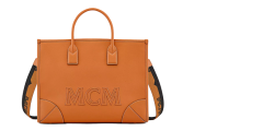 Orangefarbene MCM-Handtasche mit zwei Griffen und einem abnehmbaren schwarzen Riemen mit dem Markennamen. Die Tasche hat ein strukturiertes Design mit sichtbaren Nähten und Eckdetails und trägt auf der Vorderseite deutlich die Prägung „MCM“.