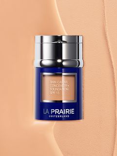 Ein blau-silberner Tiegel mit der „La Prairie Skin Caviar Concealer Foundation SPF 15“ steht auf einem cremig-beigen Hintergrund.