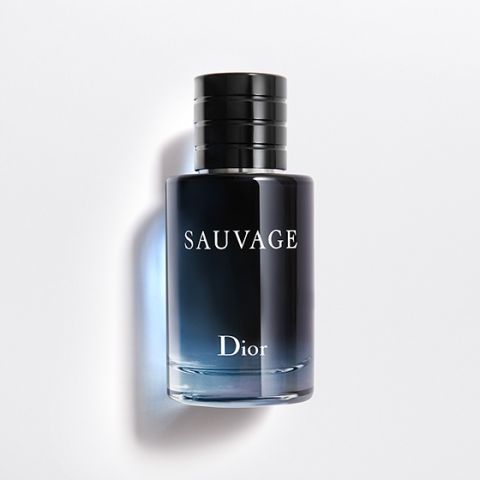 Vor einem weißen Hintergrund ist eine dunkelblaue Glasflasche mit Farbverlauf des Parfüms Dior Sauvage mit schwarzem Deckel zu sehen. Der Markenname „Dior“ und der Parfümname „Sauvage“ sind in fetten weißen Buchstaben auf der Vorderseite aufgedruckt.