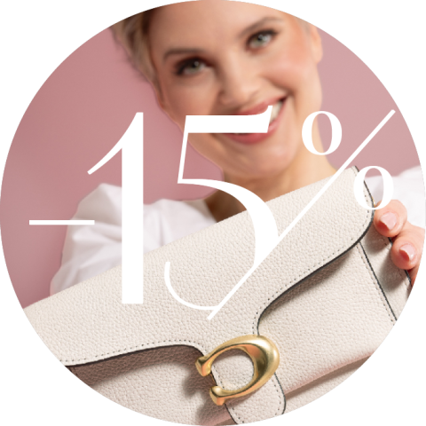 Eine lächelnde Person hält eine helle, strukturierte Handtasche mit goldenem Verschluss. Der weiße Text auf dem Bild lautet „-15 %“. Der Hintergrund ist zartrosa.