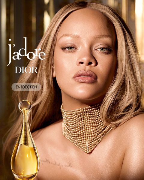 Eine Frau mit langem, glattem blondem Haar und einem goldenen Perlenhalsband posiert neben einem Flakon des Parfums J'adore Dior. Der Text lautet "j'adore DIOR" und "ENTDECKEN" vor einem goldfarbenen, eleganten Hintergrund.