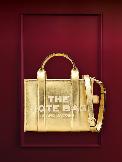 Eine strukturierte Handtasche aus Metall mit Griffen vor einem burgunderfarbenen Hintergrund. Darüber steht das Wort „WUNSCHTASCHE“.