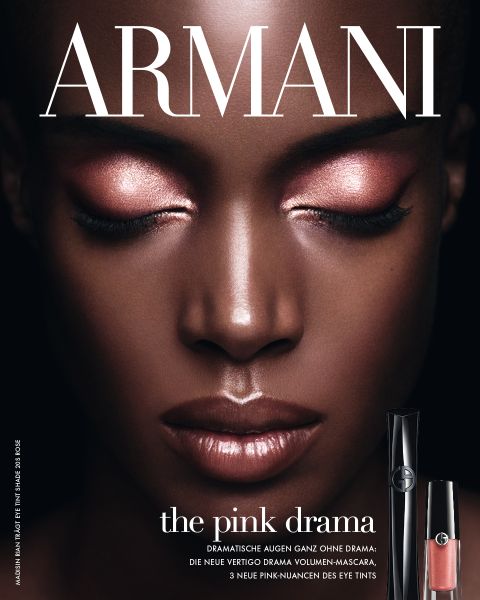 Kendall Jenner posiert vor einem roten Hintergrund mit einem Flakon des Parfums "Power of You" von Emporio Armani im Vordergrund.