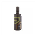 Eine braune Flasche „Aveda Men Pure-Formance Shampoo“ mit grünen und braunen Akzenten auf dem Etikett, die aufrecht auf einem weißen Hintergrund steht.