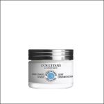 Ein weißer Tiegel mit der „Light Comforting Cream“ von L’Occitane mit schwarzem Deckel und blauem Sheabutter-Etikett, abgebildet vor einem schlichten weißen Hintergrund.