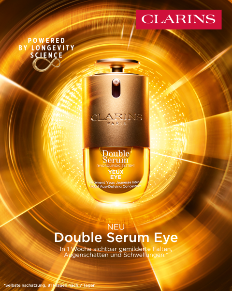Eine Clarins Double Serum Foundation Flasche steht in der Mitte vor einem leuchtenden, goldenen, abstrakten Hintergrund mit einem Text, der die Foundation als revolutionär anpreist.