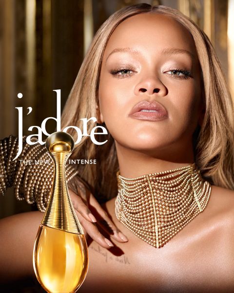 Eine Frau mit blondem Haar hält drei Dior Addict Parfümflaschen in Orange-, Rosa- und Lila-Tönen, darunter der Text "DIOR ADDICT THE NEW PERFUMES".