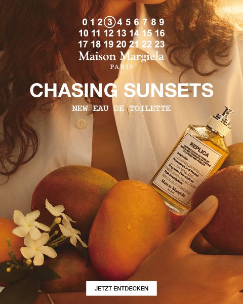 Eine Flasche des Parfüms „Replica Maison Margiela“ mit der Aufschrift „Under the Stars“ steht vor einem Sternenhimmel mit felsigem Gelände. Der Text am unteren Rand lautet: „Die Düfte, aus denen Ihre Erinnerungen gemacht sind.“.