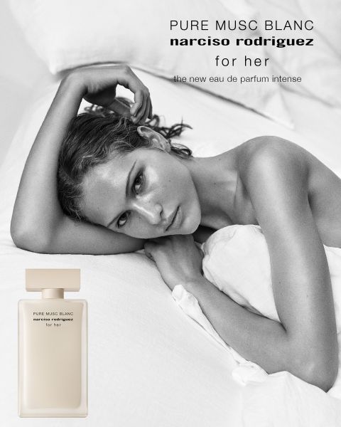 Eine Frau mit lockigem braunem Haar posiert im Profil neben einem rosafarbenen Parfümflakon mit der Aufschrift "all of me narciso rodriguez floral". Der Text darüber lautet "narciso rodriguez", und darunter: "Das neue florale Eau de Parfum".