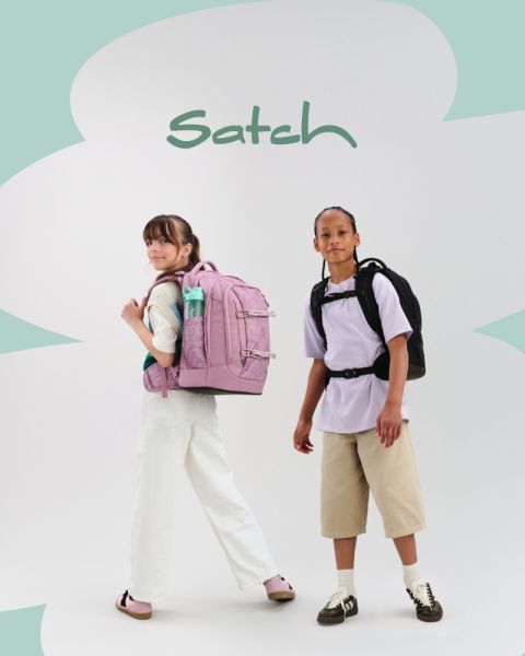 Vier Kinder mit Rucksäcken posieren kreativ in einem Studio. Eines steht auf einer Leiter und hält eine Filmklappe, ein anderes spricht in ein Megafon, zwei weitere knien und sitzen auf bunten Würfeln. Studioequipment ist zu sehen.