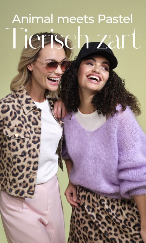 Zwei lächelnde Frauen. Eine trägt eine Jacke mit Leopardenmuster, eine rosa Hose und eine Sonnenbrille, die andere eine schwarze Mütze, einen lila Pullover und einen Rock mit Leopardenmuster. Der Text lautet: „Animal meets Pastel Tierisch zart“ auf grünem Hintergrund.