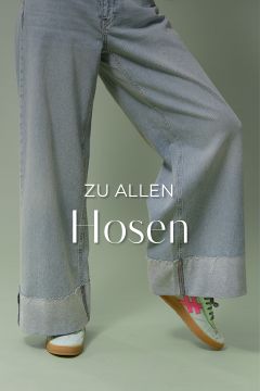 Eine Person in weiten, hellblauen Jeans mit ausgefransten Säumen und weißen Sneakers mit rosa und grünen Details steht auf einem Bein. Der Text lautet „ZU ALLEN Hosen“. Der Hintergrund ist in gedecktem Grün gehalten.