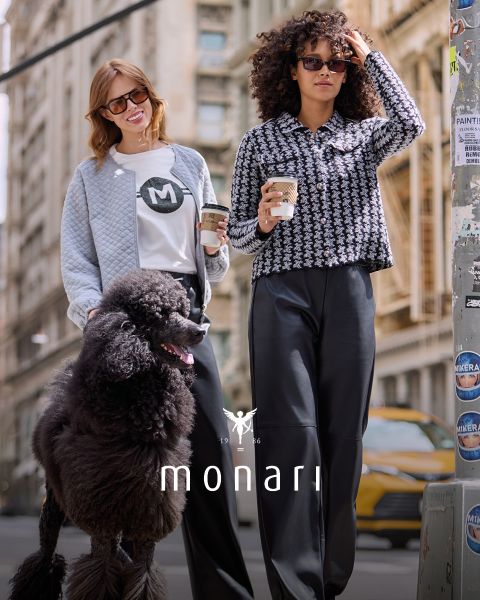 Zwei Frauen in stylischer Freizeitkleidung und Sonnenbrillen gehen mit Kaffeetassen eine Stadtstraße entlang; eine hält einen schwarzen Großpudel an der Leine. Am unteren Bildrand ist das Wort „monari“ zu sehen.