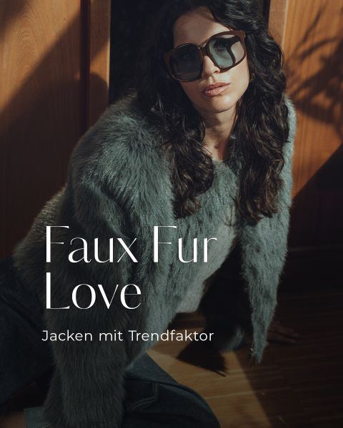 Eine Frau mit langen dunklen Haaren und großer Sonnenbrille trägt eine graue Kunstpelzjacke und sitzt auf einem Holzboden. Das Sonnenlicht wirft Schatten. Der Text lautet: "Faux Fur Love. Jacken mit Trendfaktor.