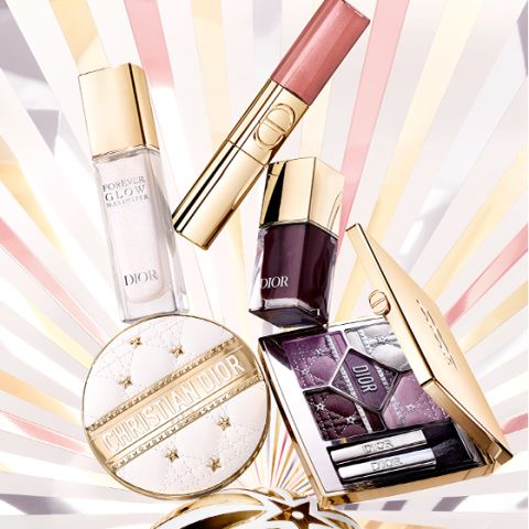 Fünf Make-up-Produkte von Dior, darunter eine Grundierung, ein Lipgloss, ein Nagellack, eine Lidschattenpalette und ein Kompaktpuder, werden auf einem strahlenden Hintergrund in Gold und Pastellfarben präsentiert.
