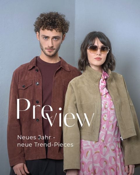 Ein Mann in einer braunen Jacke und eine Frau mit Sonnenbrille, hellbrauner Jacke und rosa Kleid posieren vor einer grauen Wand. Text: "Vorschau Neues Jahr - neue Trend-Pieces".