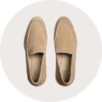 Ein Paar beigefarbene Wildleder-Slipper von oben gesehen auf hellem Hintergrund.