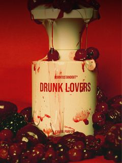 Ein Parfümflakon mit der Aufschrift "DRUNK LOVERS" ist mit roter Flüssigkeit bespritzt und von Kirschen und Beeren vor einem tiefroten Hintergrund umgeben.