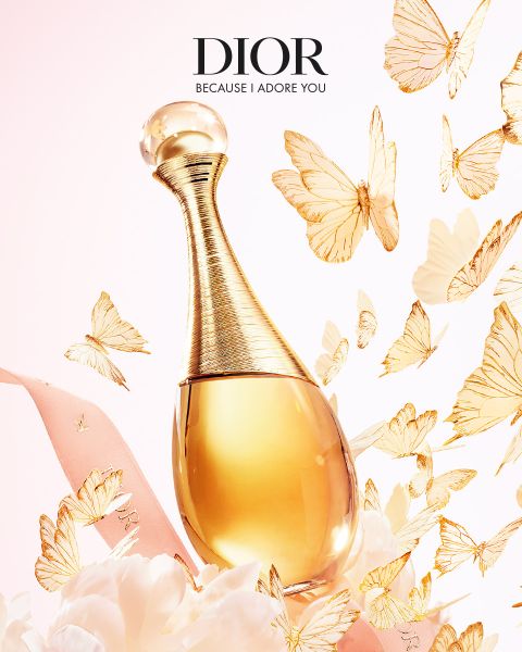 Ein goldener Dior-Parfümflakon, umgeben von schwebenden goldenen Schmetterlingen, rosa Schleife und zarten weißen Blumen mit dem Text "DIOR Because I Adore You".