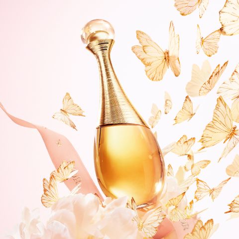 Goldene Parfümflasche, umgeben von einem rosa Band, weißen Blumen und flatternden goldenen Schmetterlingen auf einem pastellfarbenen Hintergrund.