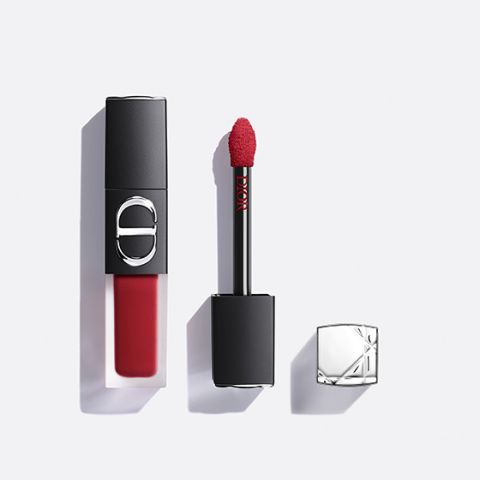 Ein roter flüssiger Lippenstift von Dior, dessen Applikator herausgezogen ist und dessen silberne Kappe daneben liegt, alles vor einem weißen Hintergrund.
