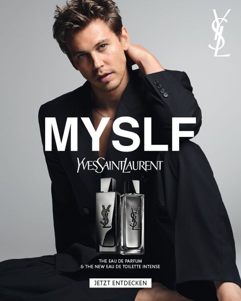 Ein Mann in einem schwarzen Anzug sitzt hinter zwei YSL-Parfümflakons, über denen in großen Buchstaben „MYSLF“ und das YSL-Logo zu sehen sind.